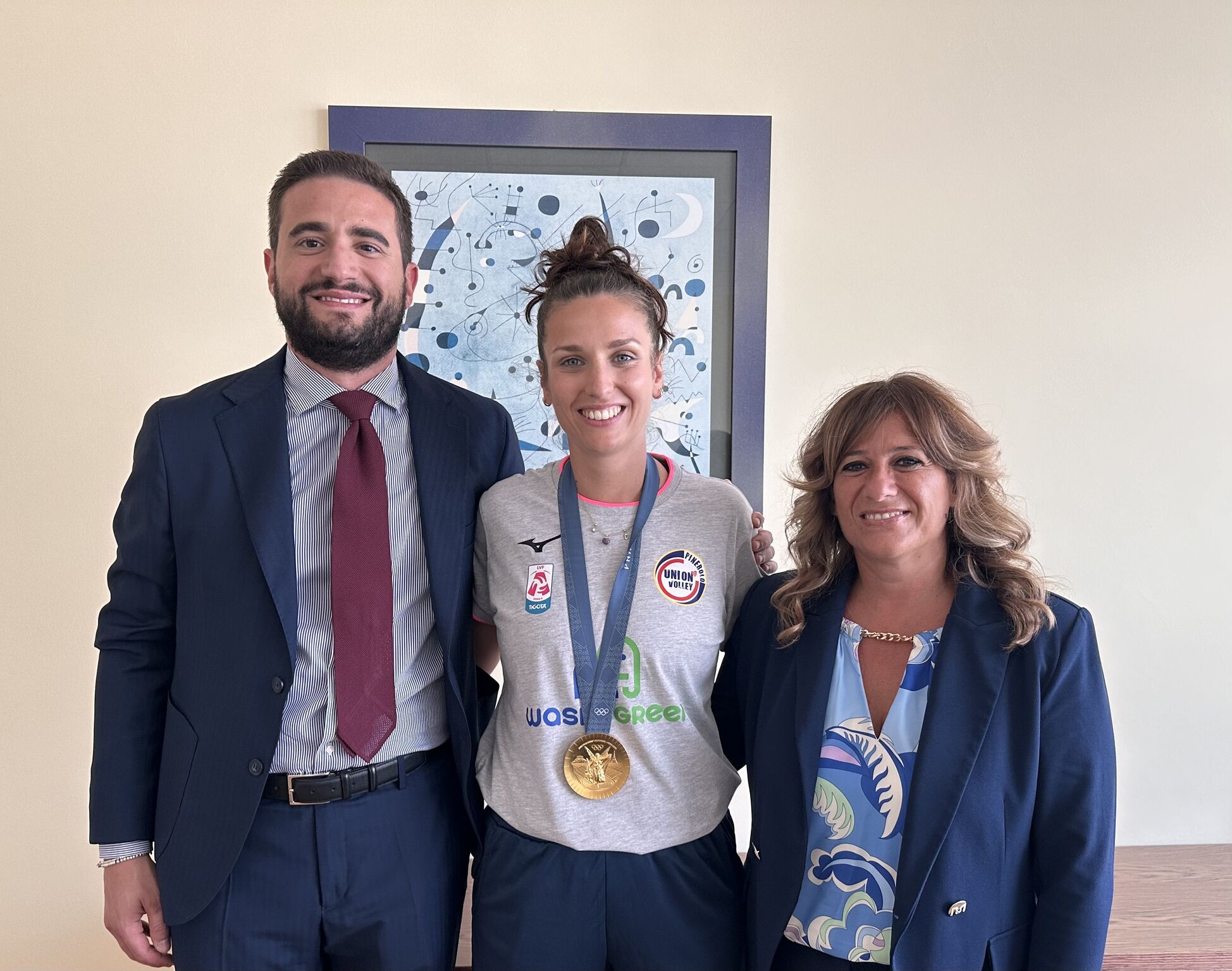 Foto di due persone che festeggiano un'atleta con medaglia