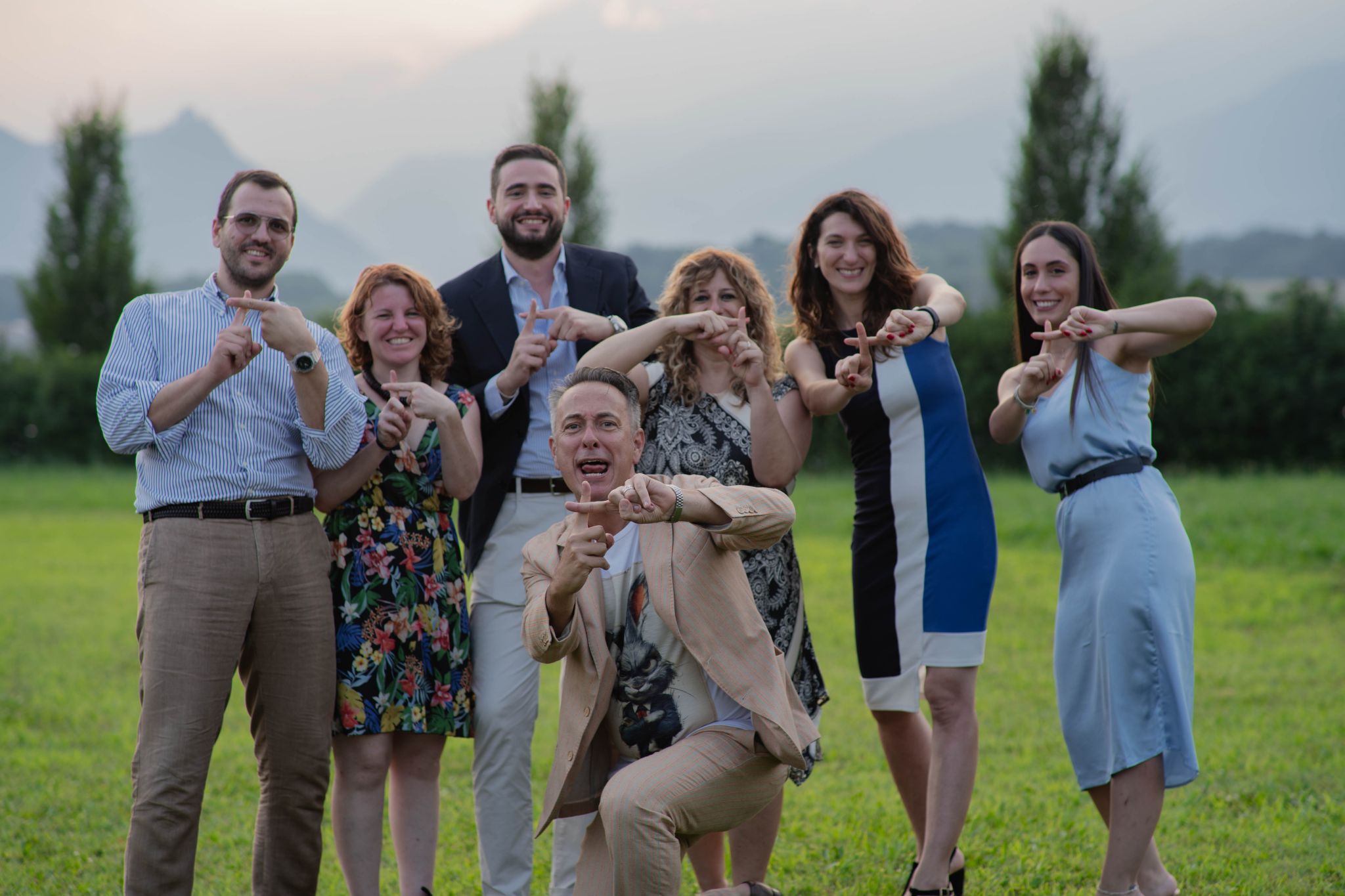 Foto di gruppo di persone che fa un più con le dita